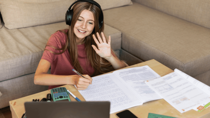 A professional woman in her home office participates in a video conference, showcasing the technology that enables effective team collaboration in a hybrid work environment.