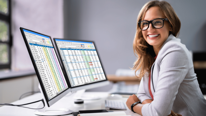 Business professional in Germany reviewing supply chain data on dual monitors to assess the impact of U.S. Tariffs.