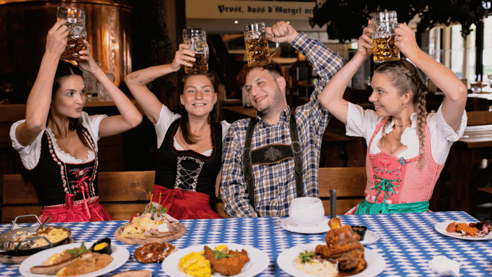 People enjoying traditional dishes and lively atmosphere at a food festival, highlighting German tourism.