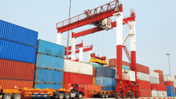 German industrial port with shipping containers being loaded, symbolizing export operations affected by U.S. Tariffs.