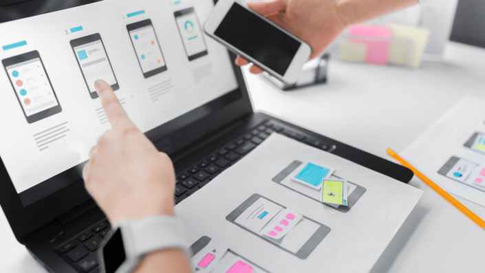 UX designer planning mobile app interface to make money online with digital products.