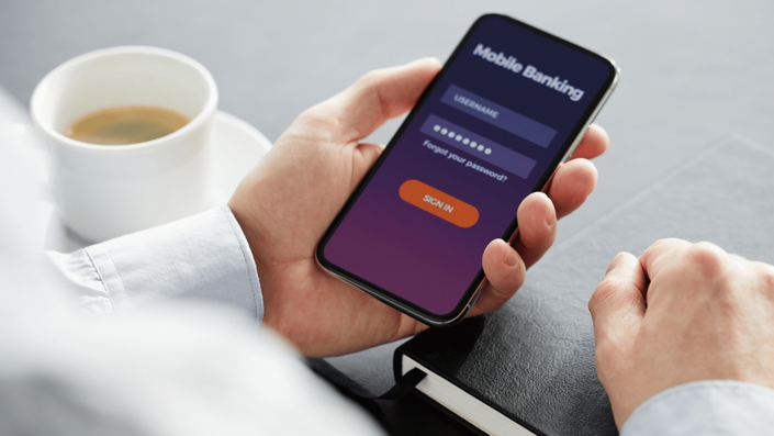 Person using a mobile banking app for secure transactions, highlighting the impact of FinTech innovations in everyday banking.