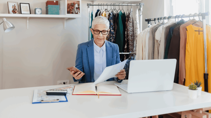 A focused, self-employed man in his late 40s works on a laptop in a modern office space, reflecting the new provisions for freelancers within the German Pension System.